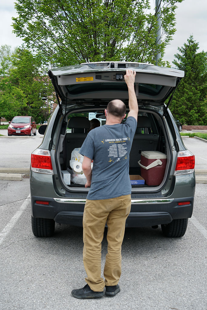 Jason Delpire prepares to close the trunk door after he delivers requested books to the reader